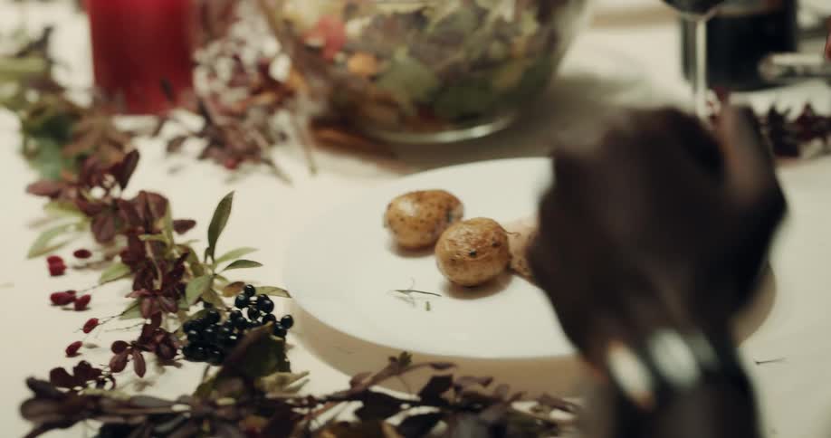 Man sitting at table for holiday dinner serves himself then picks up utensils