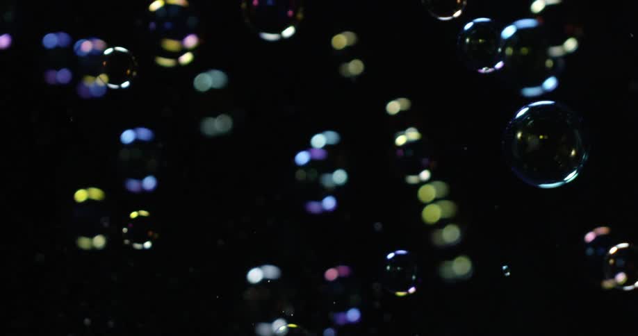 Bubbles and water fly around a dark area