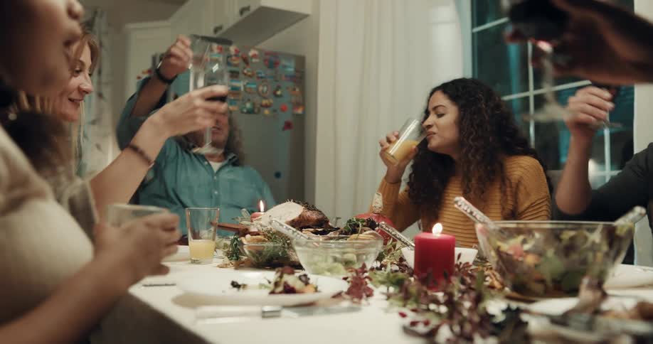 People toasting and celebrating gathered around dinner table