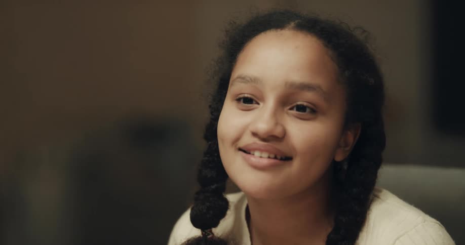 A teenage girl smiles and gestures as she talks then shrugs away from her mom