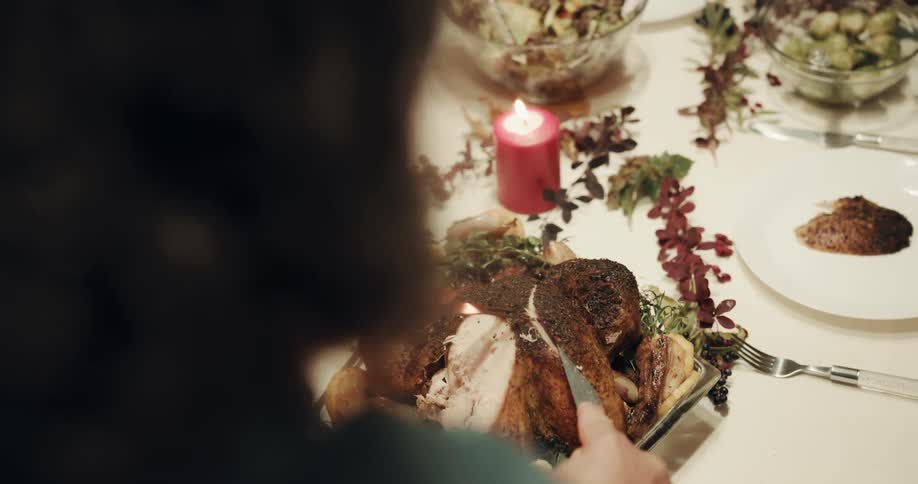 Point of view shot of a turkey being carved and served at the dinner table