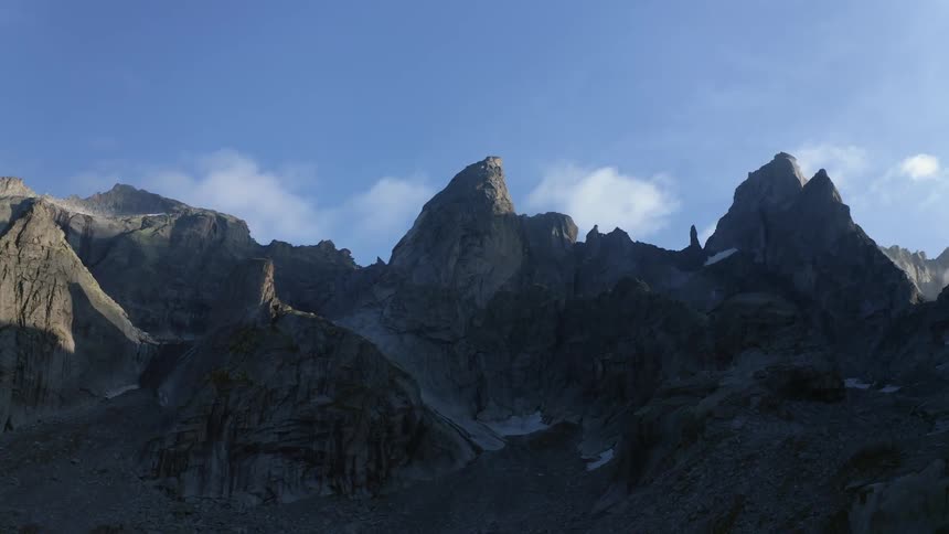 The mountain is in the shade on a sunny day