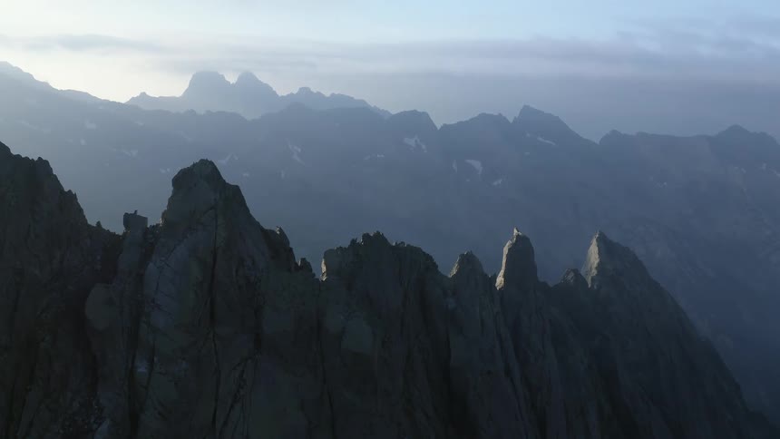 Jagged rock peaks on the ridge of a mountain range at sunrise