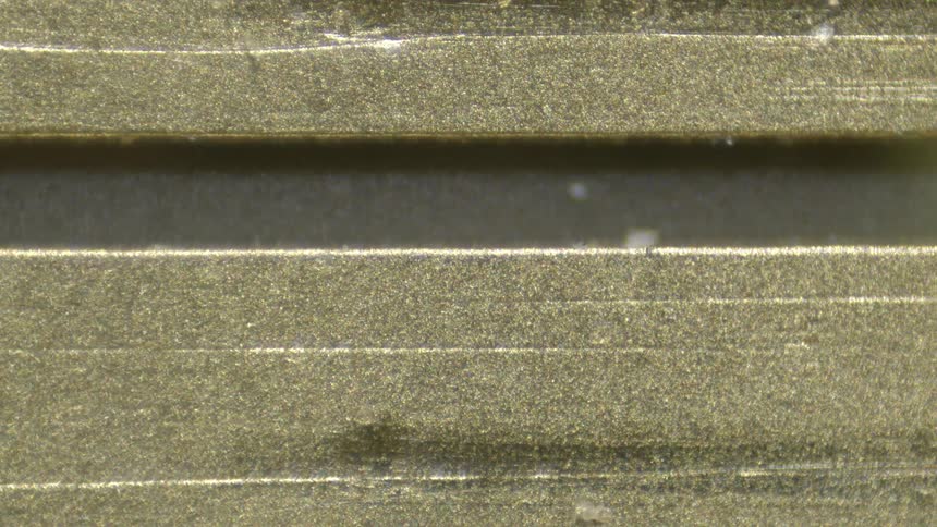 Gold rectangles sit in rows on surface of moving part