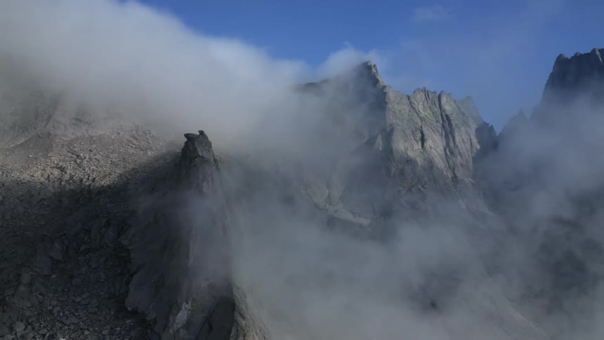 A mountainside shrouded in mist on a clear day