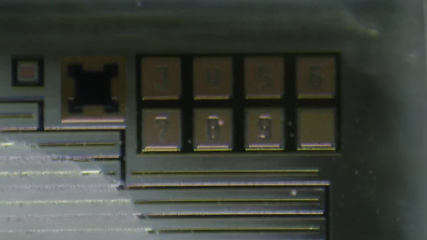Out of focus close up of a row of buttons on a machine behind a glass