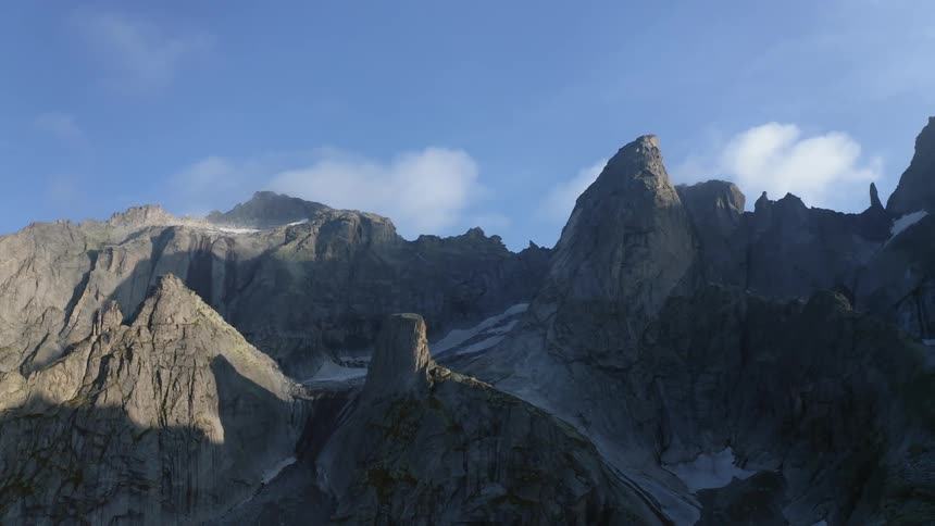 A rocky jagged mountain ridge with traces of snow on the slope