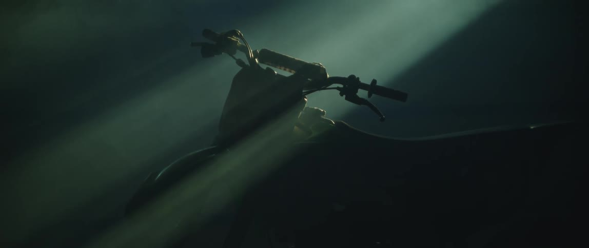 Light shines dimly on a motor bike indoors