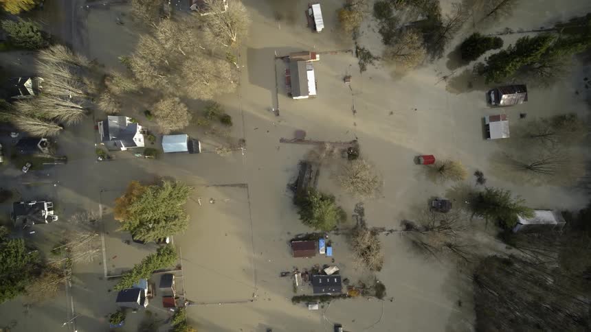 Birds eye view of homes and property submerged under murky floodwater