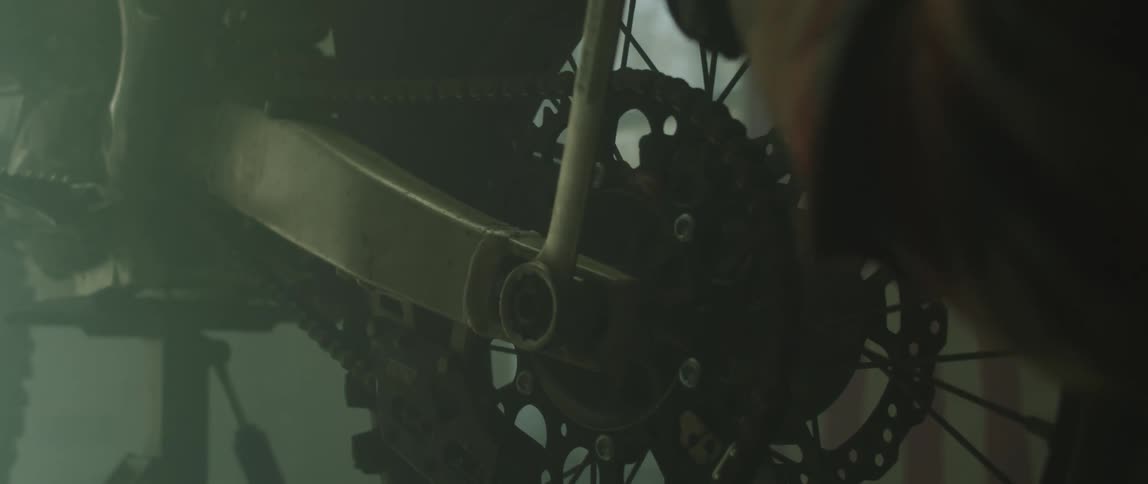 A mechanic is using a wrench to turn a bolt on a motorcycle wheel