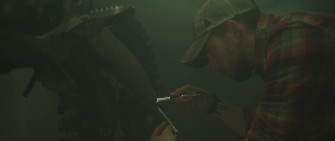Man works on bike with two crescent wrenches