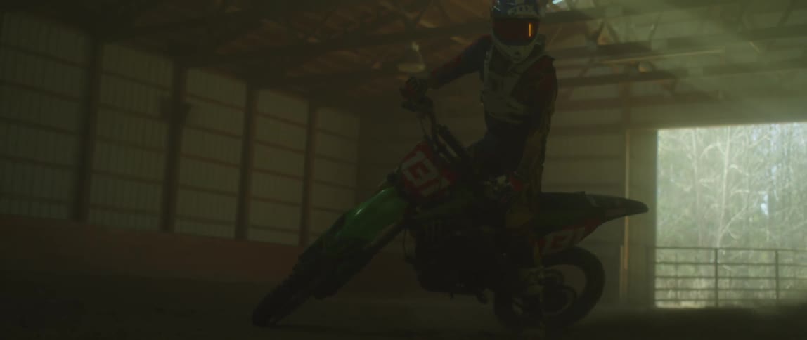 Person riding dirt bike in an indoor arena