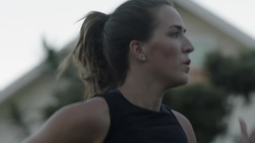 A woman jogs past some houses