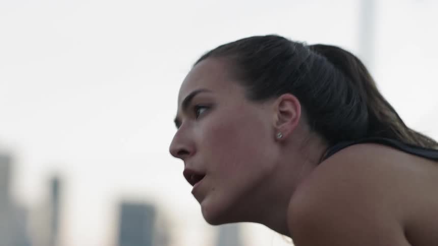 A woman is leaning forwarding taking a breath