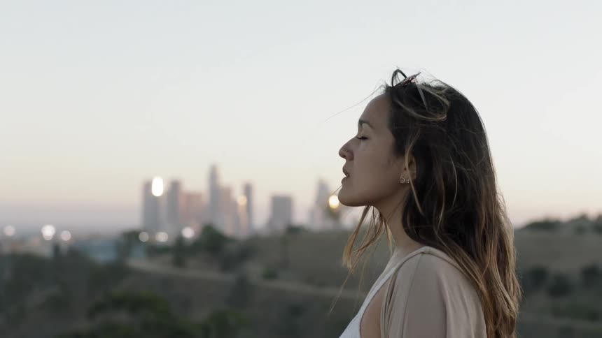 A woman looks at the sky on a windy day