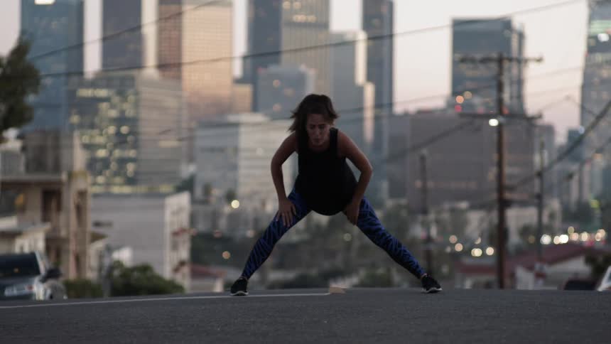 A woman stretches in the street