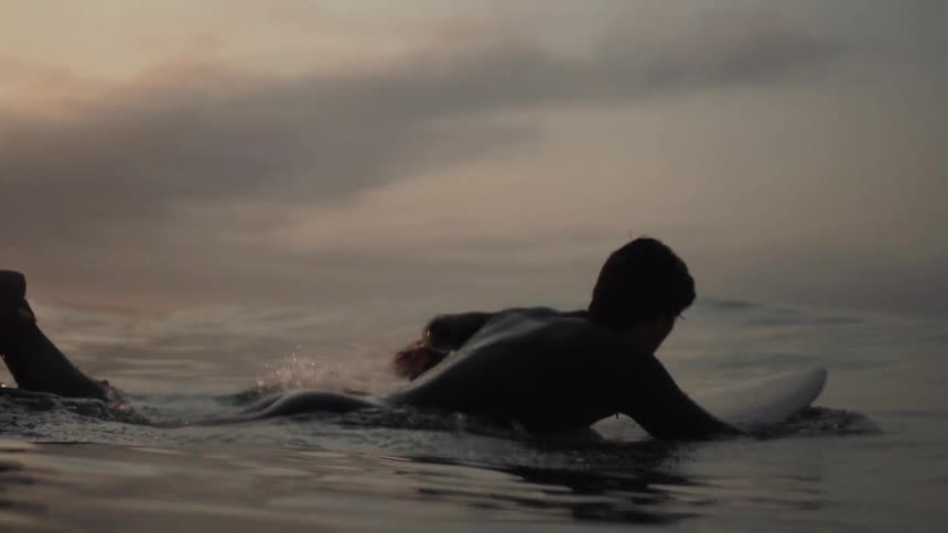 A man paddles on a surfboard in a body of water