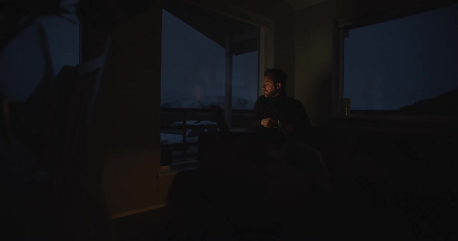 A man uses his laptop and drinks from a mug