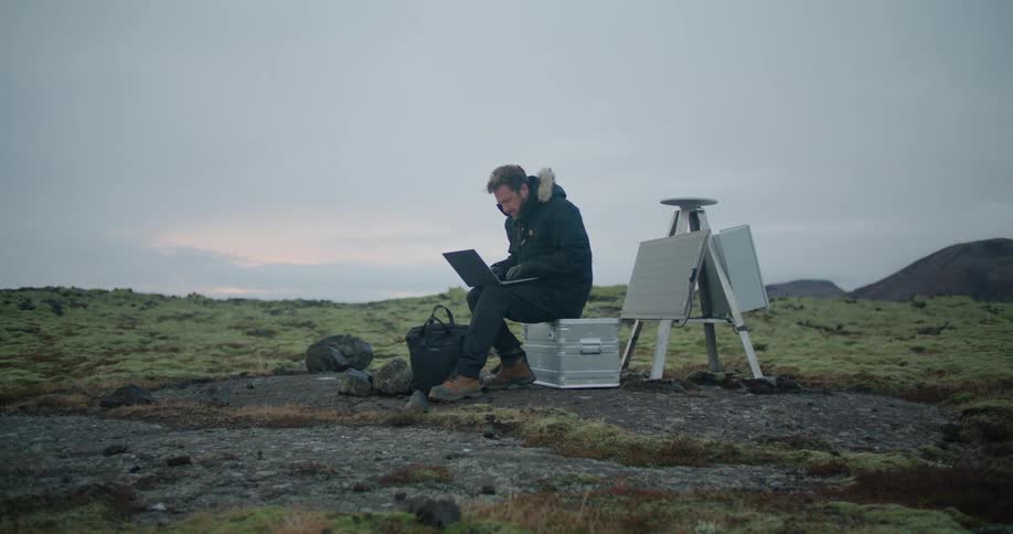 A man sitting outside on a laptop
