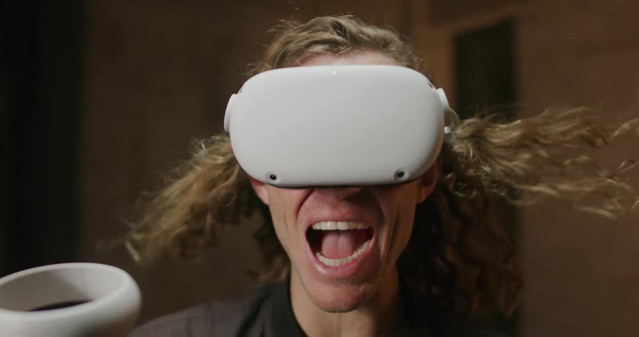 Close up of man with hair blowing screaming wearing virtual reality headset