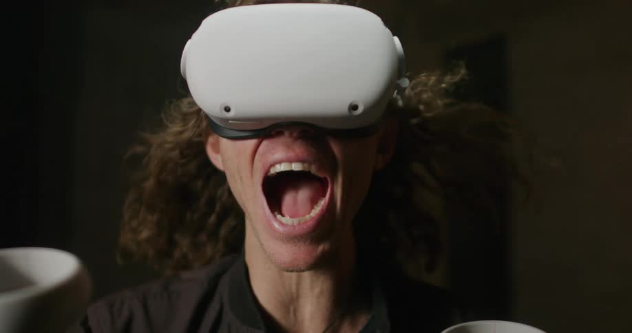 The wind blows the mans hair back as he uses a virtual reality headset