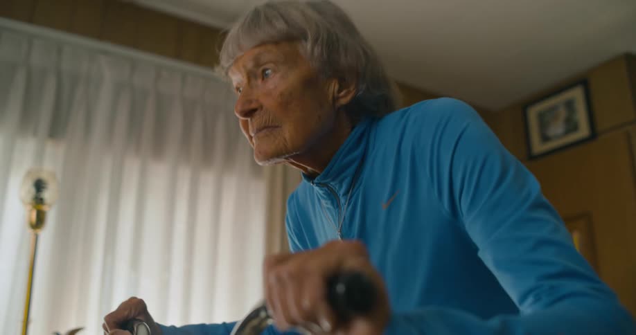 Woman rides exercise bike standing in living room