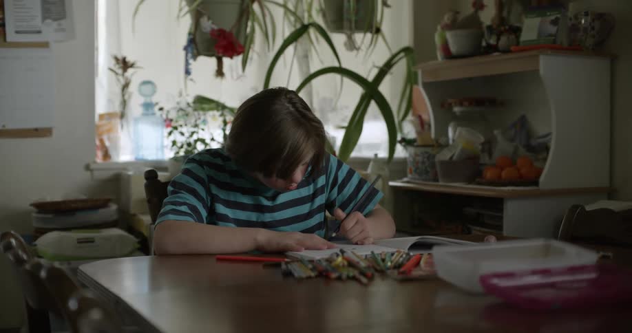 A person sits at a table writing in a notebook