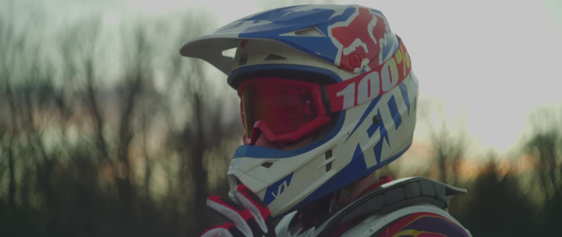 A man in motocross equipment turns their head