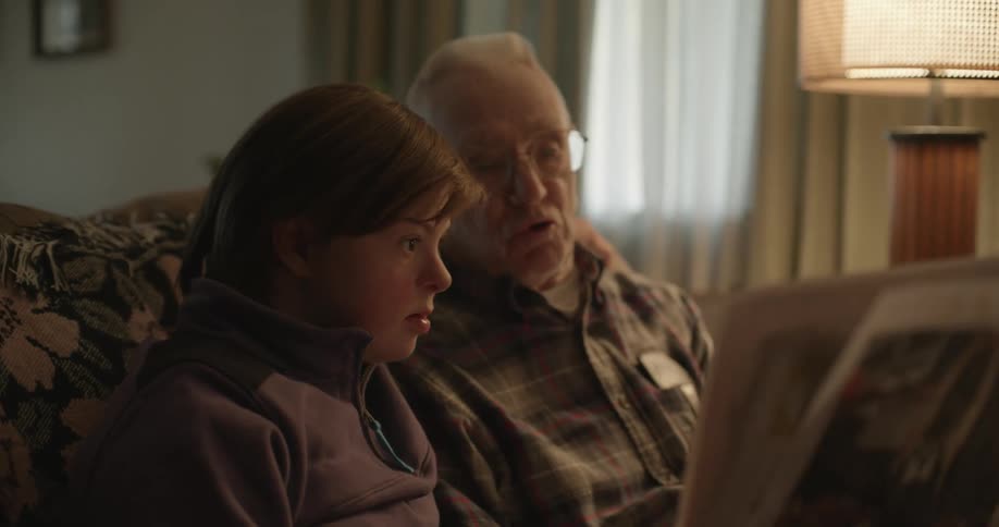 A man and girl read a newspaper together