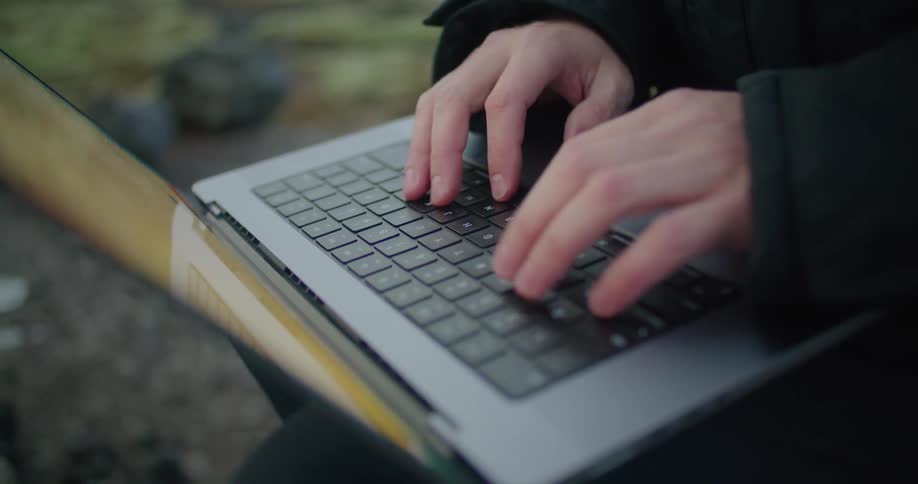 Someone has a laptop computer sitting on their legs and they are typing