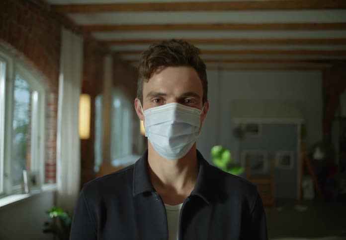 A young man is wearing a face mask