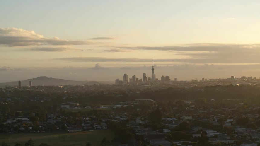 Aerial viewof a radio or television tower on the skyline of a city at sunset
