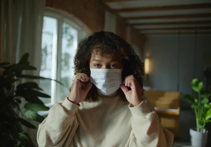 A woman puts on her medical mask