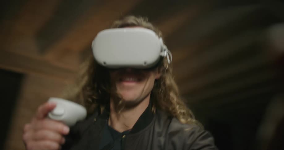 A man is spinning around as he plays a game on a virtual headset