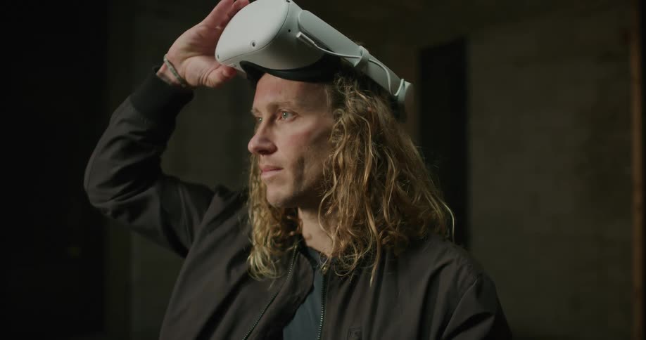 Blonde man raises vr headset
