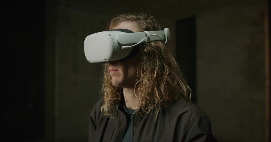 Man putting on a virtual reality headset in a dark room