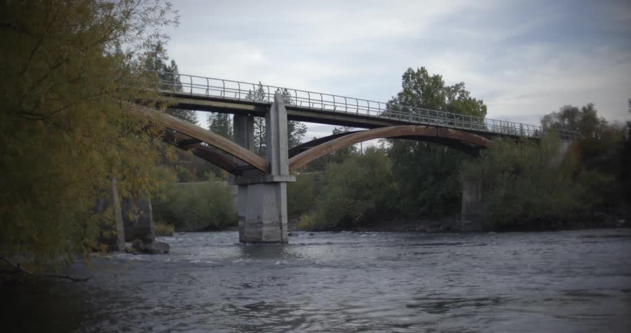 A railroad bridge spans over a wide river