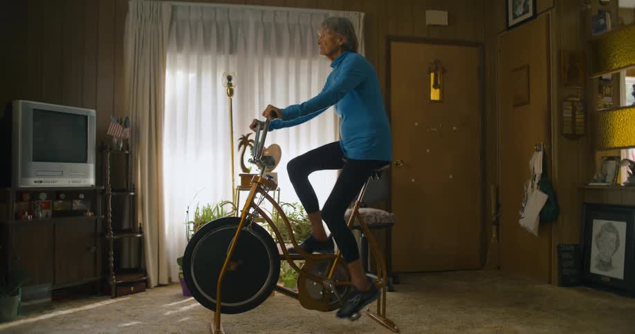 A woman rides a stationary bike at home