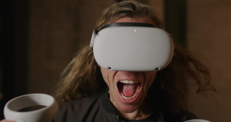 A man wearing virtual reality headset screaming as wind blows through his hair