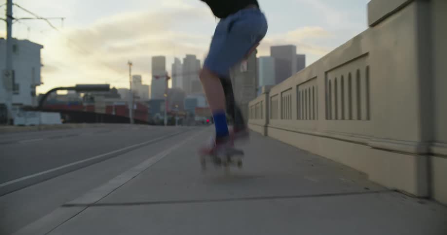 A man is skateboarding on the sidewalk