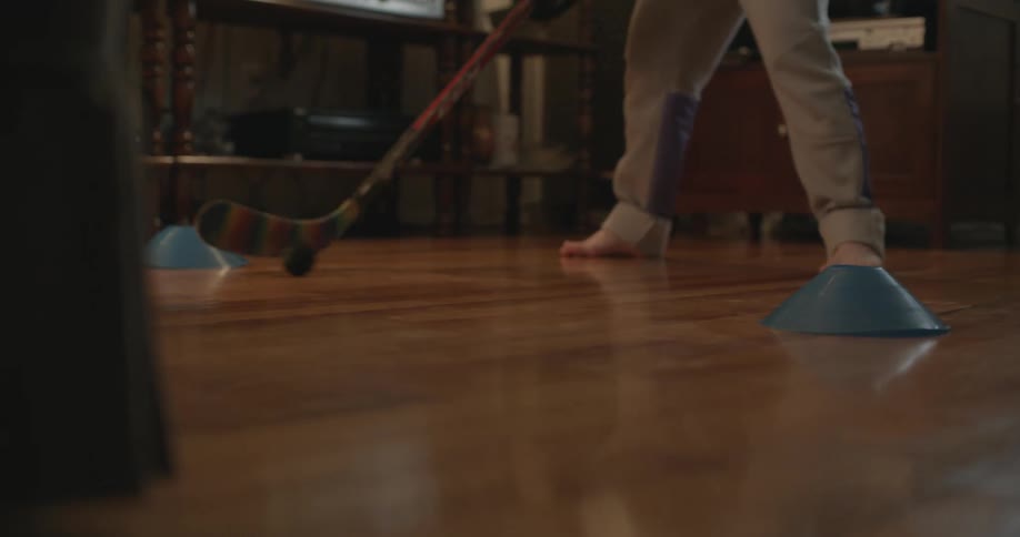 A person is hitting a ball with a hockey stick