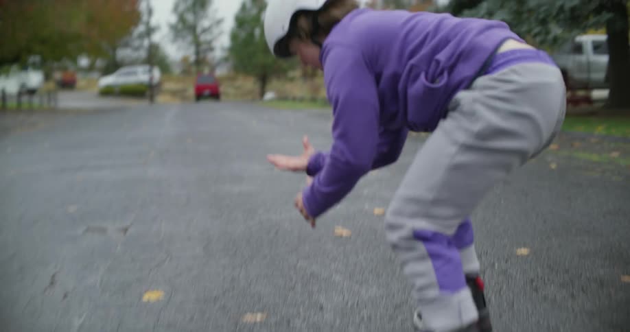 A child falls in the street on rollerblades