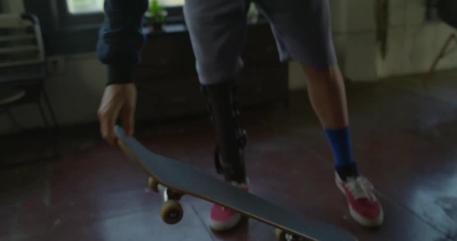 A man stands on his skateboard inside
