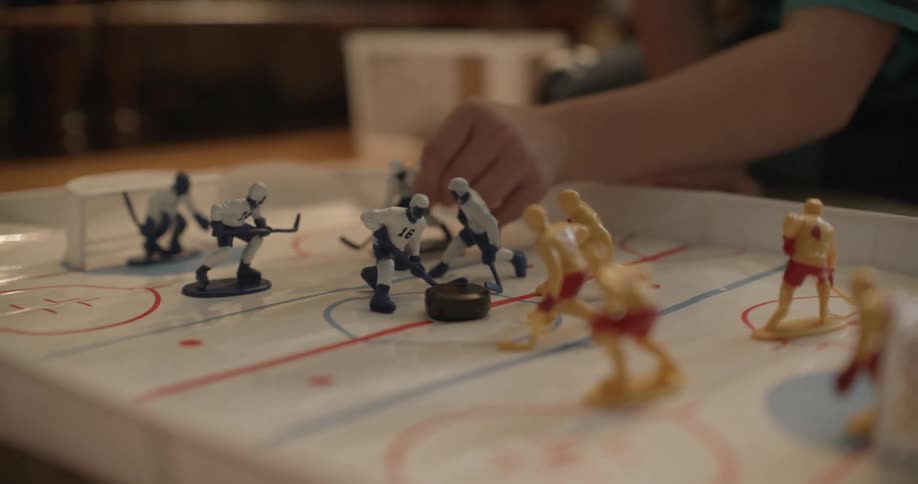 A child is playing with hockey figures
