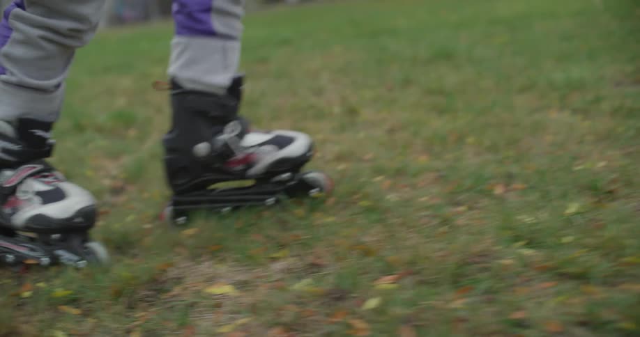 A person walks on the grass in their rollerblades