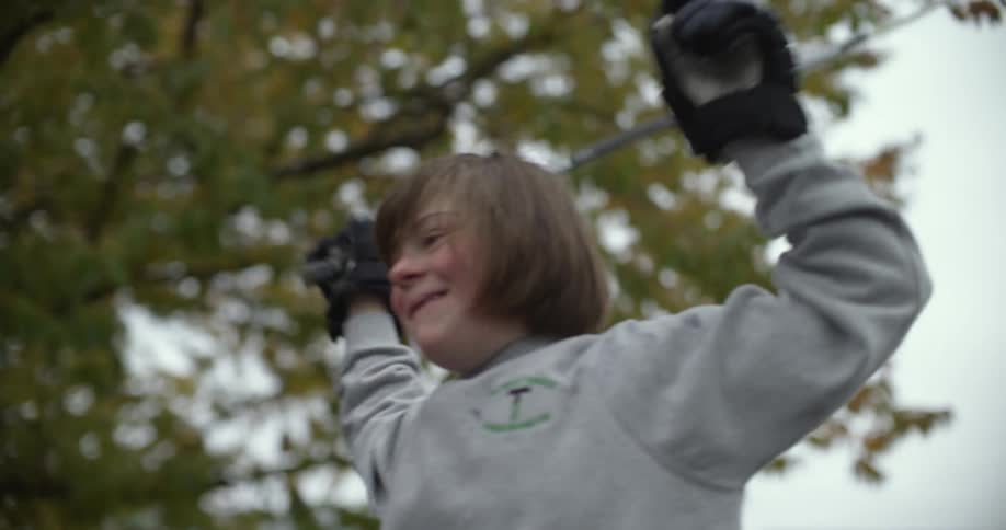 A girl swings a hockey stick above her head