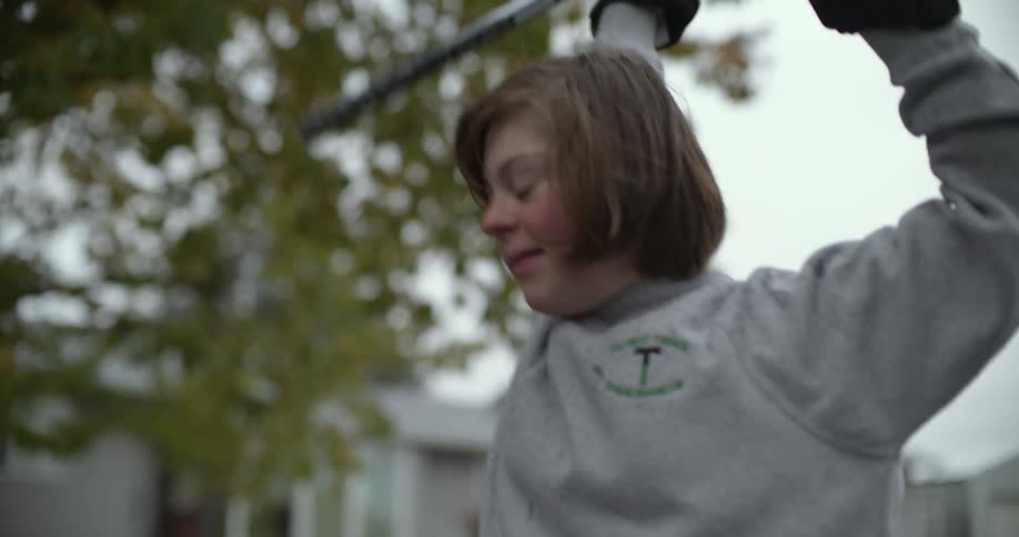 A girl throws up her arms and cheers while playing hockey outside