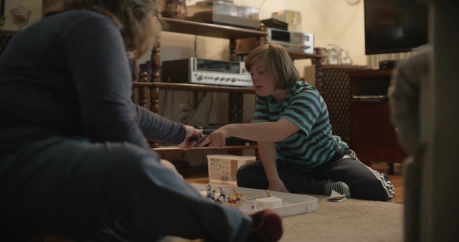 Two people sit on the floor and play a game together
