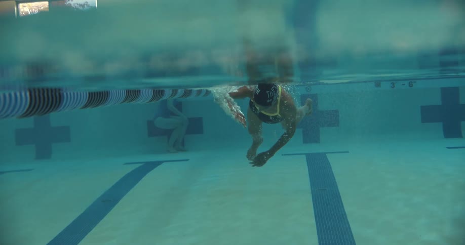 A woman swims laps in an indoor pool