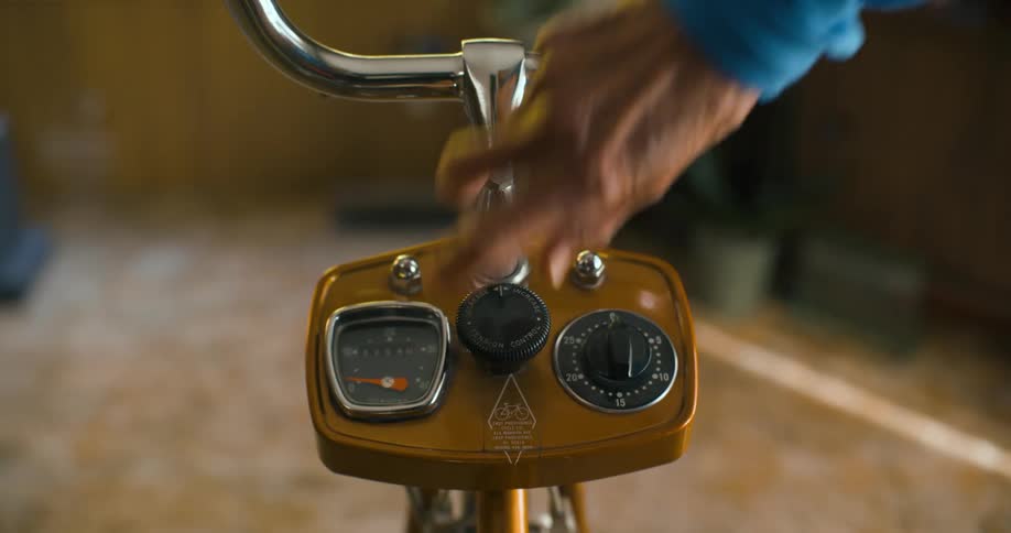 A person adjusts the knob on the stationery bike